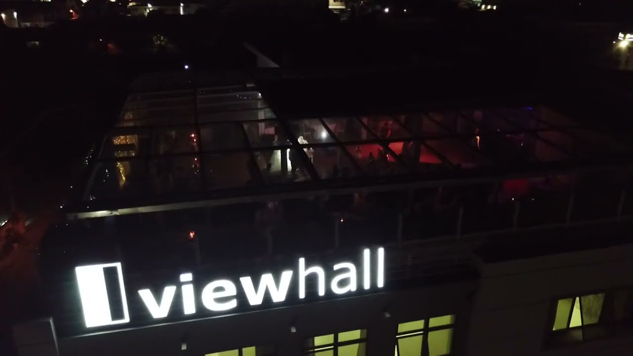 Viewhall Πολυχώρος τη νύχτα, φωτισμένη επιγραφή "viewhall" στην πρόσοψη
